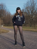 Jeny Smith in NYPD hoodies shows her legs in black seamless pantyhose outdoors